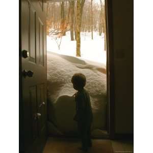  Little Boy Checks Out a Snow Drift against a Front Door 